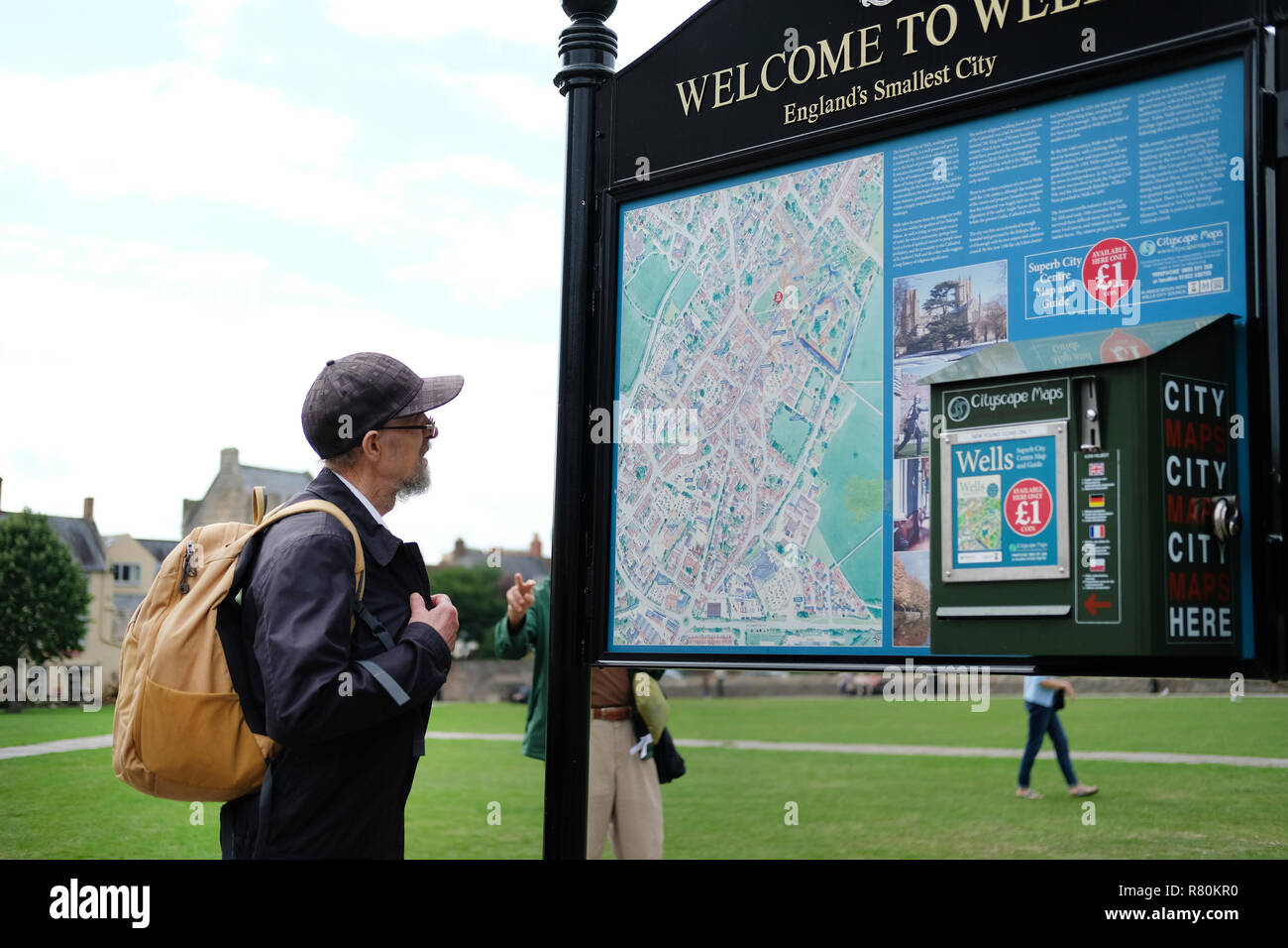 Un turista la lettura di una mappa sul verde all'esterno Cattedrale di Wells. Foto Stock