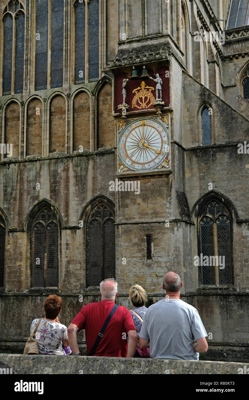 I turisti in attesa per i cavalieri di colpire le campane sui pozzetti Cathedral​ orologio nel Somerset. Foto Stock