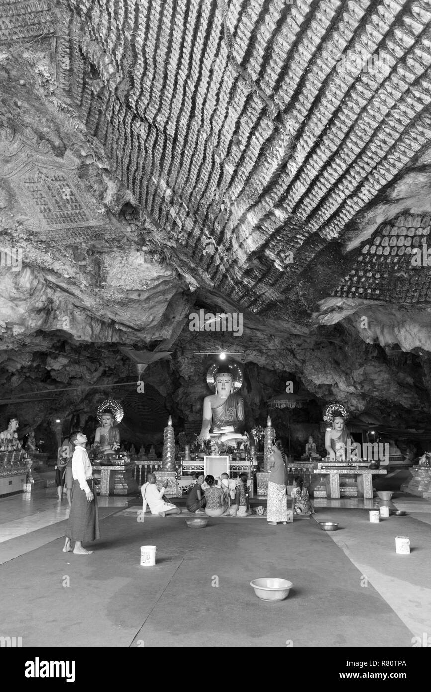 Di Hpa-an, MYANMAR - 19 novembre, 2018: foto in bianco e nero di persone locali pregando davanti di statue di Buddha all'interno di Kaw Ka Thaung Grotta, trova Foto Stock