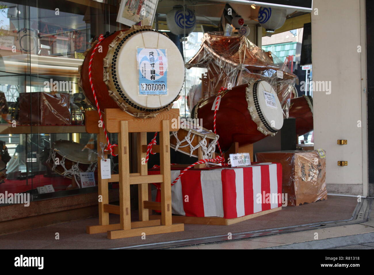Un negozio vendita giapponese tamburi taiko e altri beni per il Festival in Tokyo area di Asakusa. Foto Stock