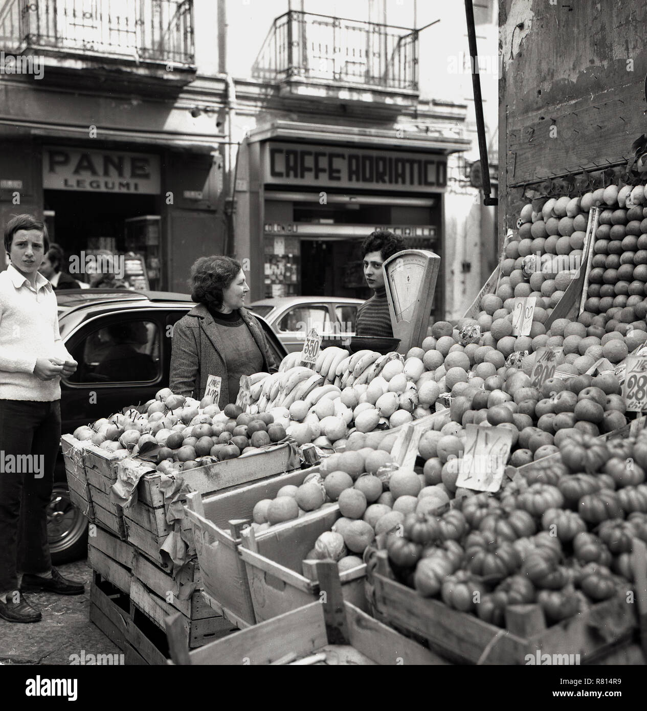 Degli anni Cinquanta, storico, un commerciante di sesso femminile presso il suo open-air di stallo del mercato per la vendita di frutta su un angolo di una strada, Napoli, Italia, Foto Stock