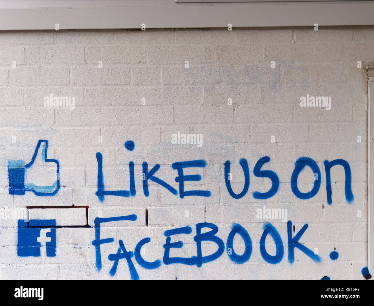 'Like us on facebook' chiamata all azione dipinta su un muro di mattoni, Regno Unito Foto Stock
