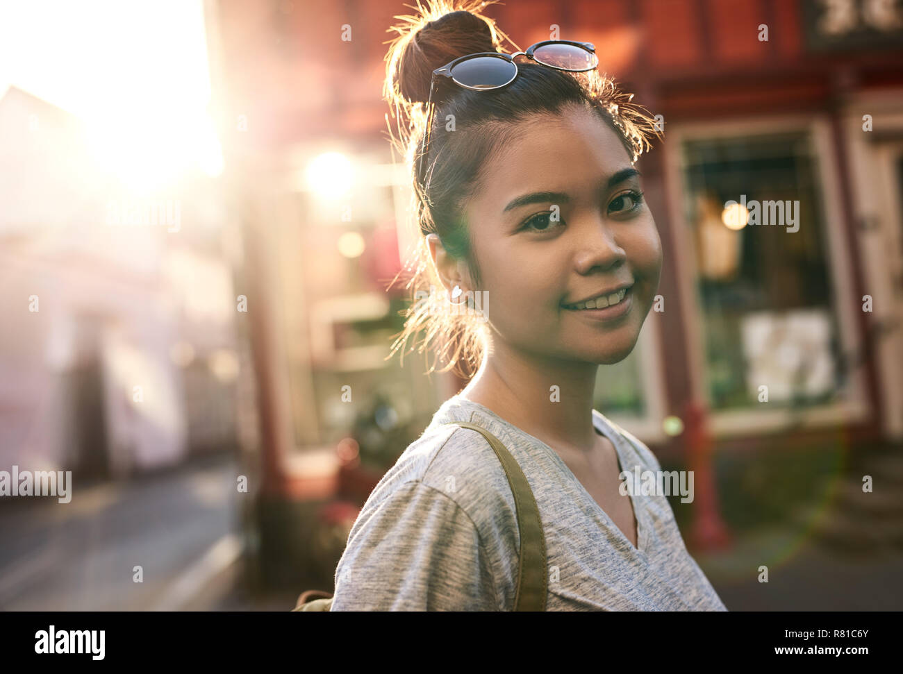 Sorridente giovane donna asiatica passeggiate in città Foto Stock