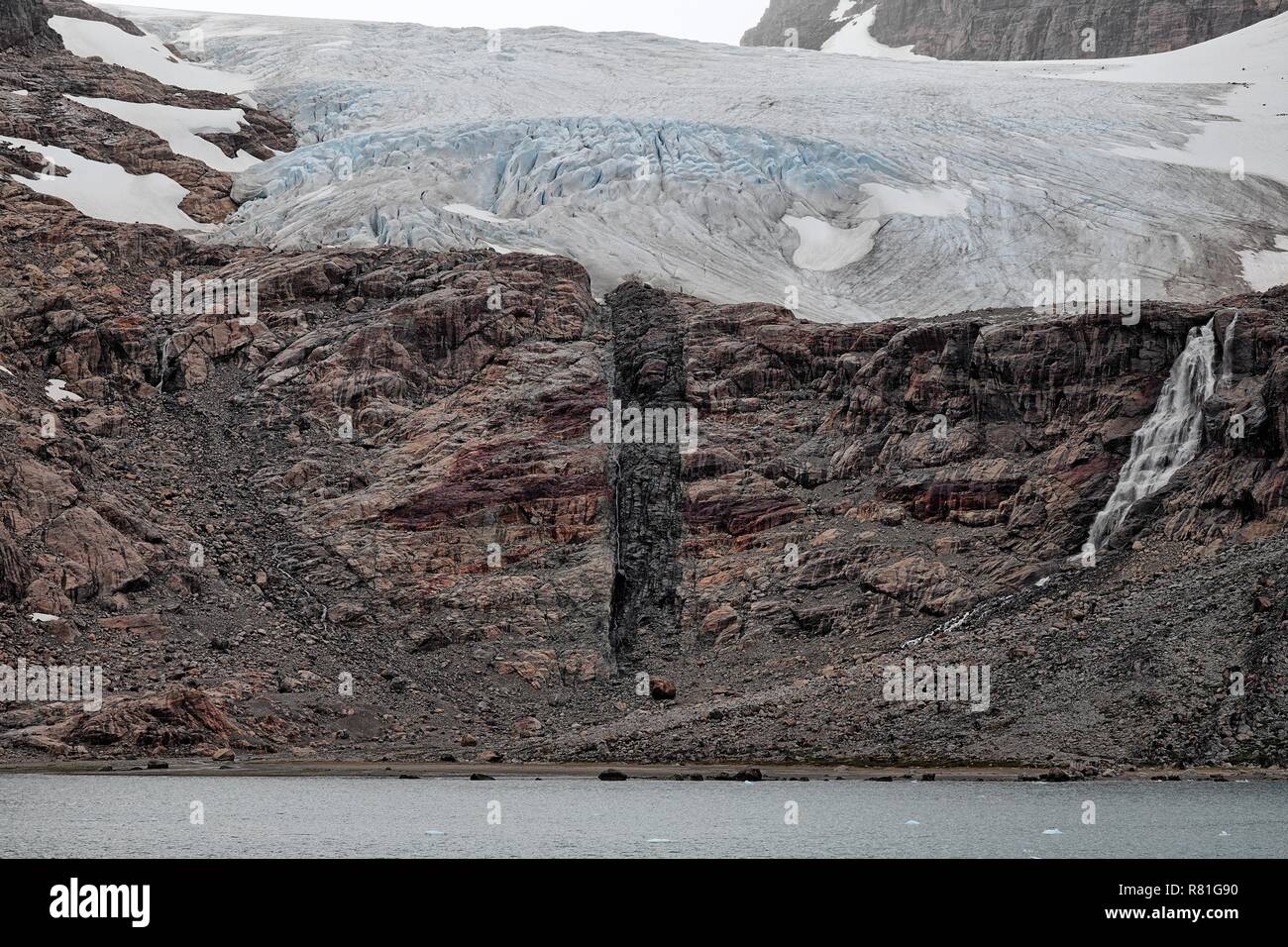 Auf einem Felsen sieht man die Abbruchkante eines Gletschers. In der Mitte erkennt man das Tauwasser, Prinz Christian Sund a Grönland Foto Stock