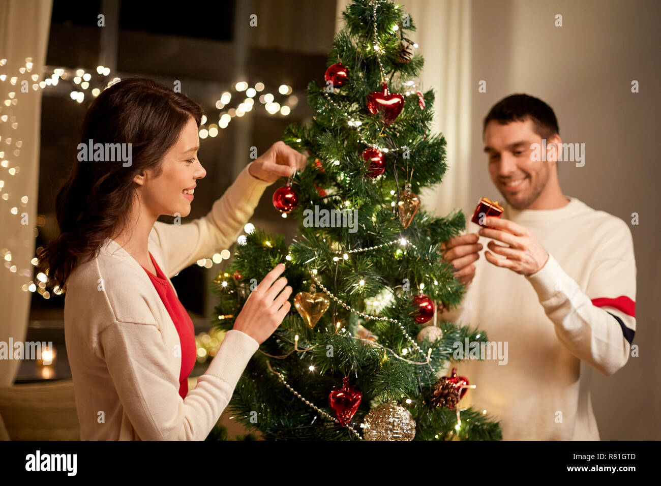 Coppia felice decorazione albero di Natale a casa Foto Stock