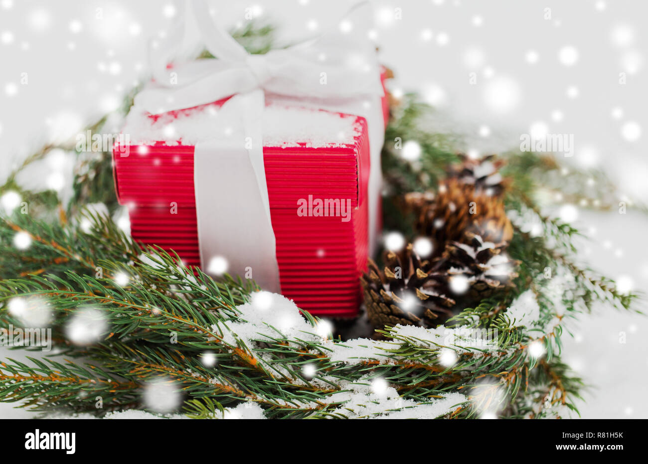 Regalo di natale e fir corona con i coni sulla neve Foto Stock