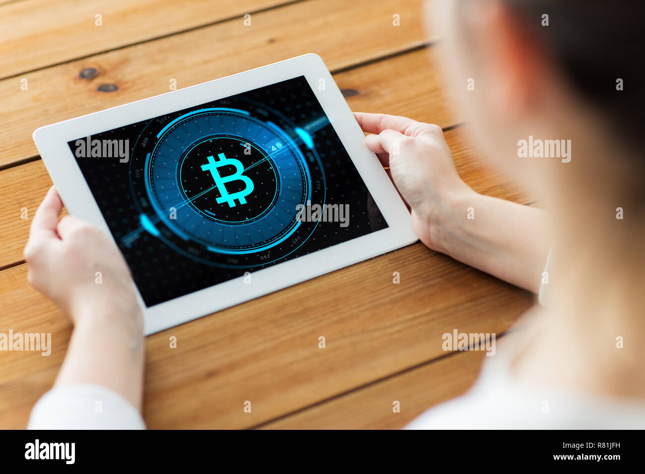 Mani con bitcoin su tablet pc sullo schermo del computer Foto Stock