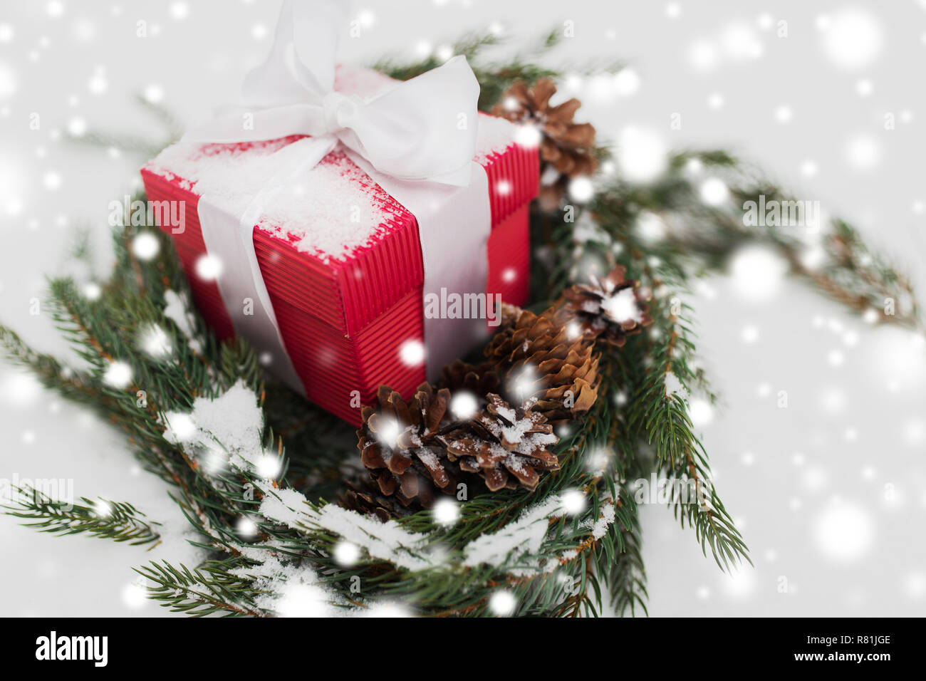 Regalo di natale e fir corona con i coni sulla neve Foto Stock