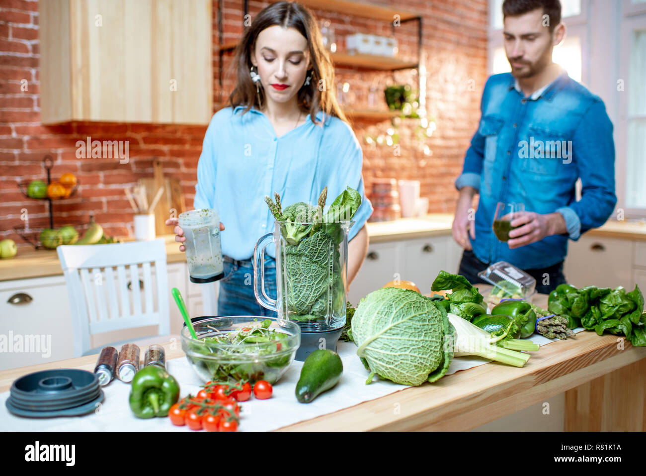 Coppia giovane di vegetariani su la cucina con il verde il cibo sano Foto Stock