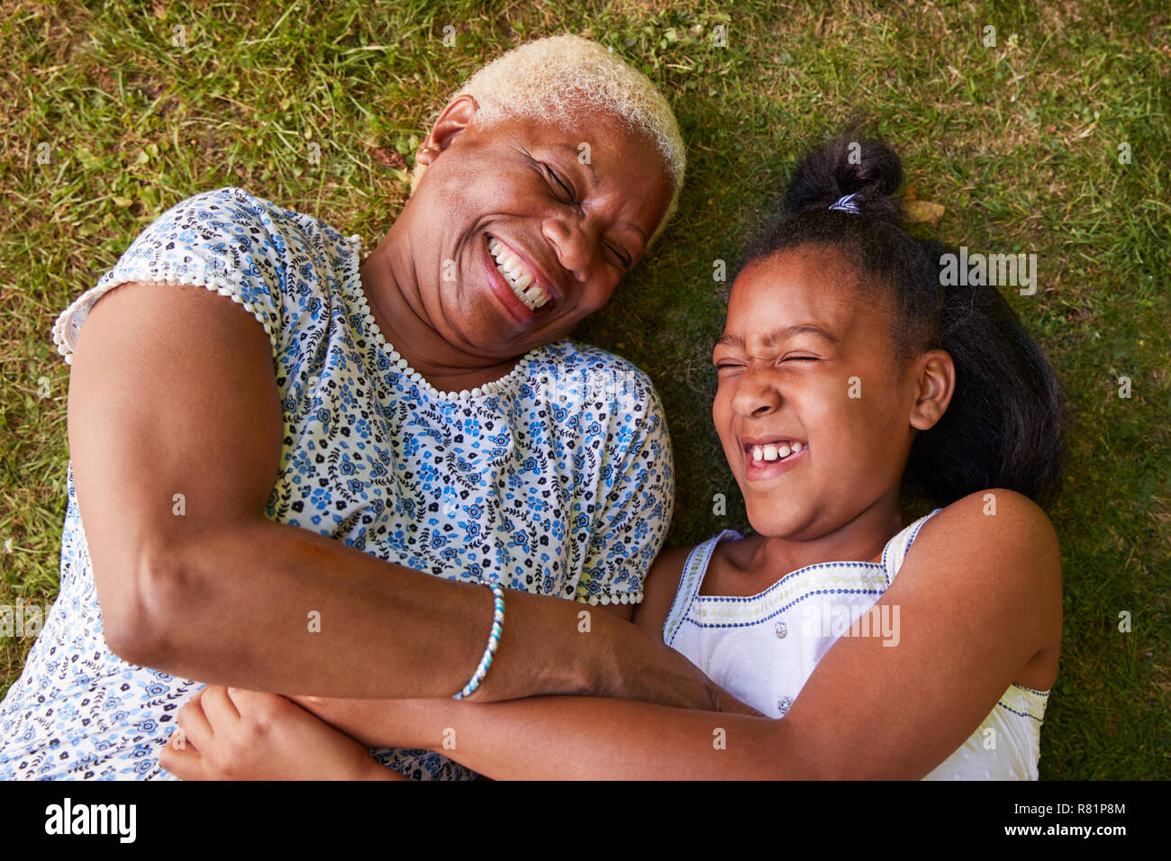 Ragazza nera e la nonna giacente su erba, overhead vicino fino Foto Stock