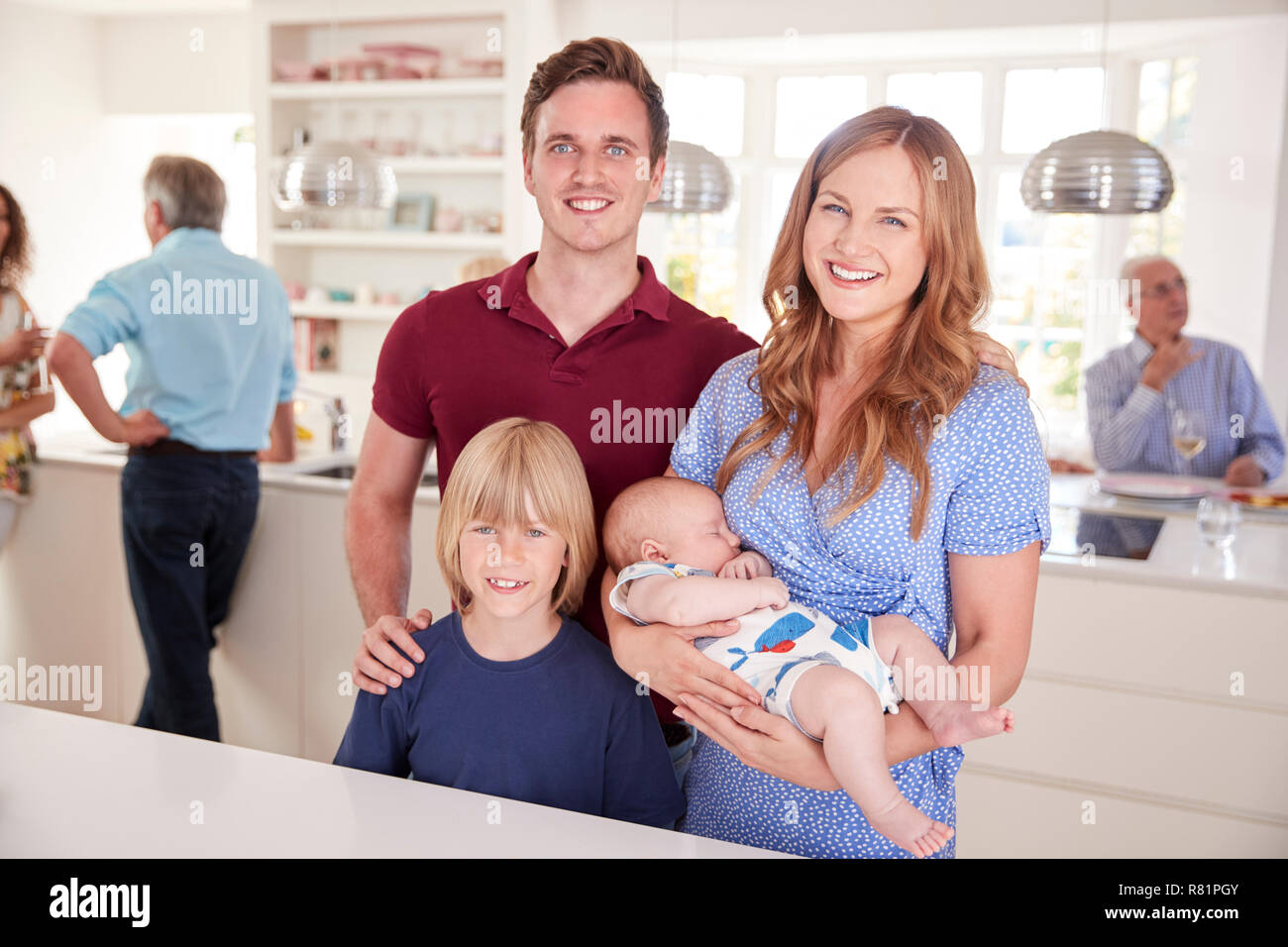 Ritratto di famiglia con amici in cucina per Multi-Generation Party Foto Stock