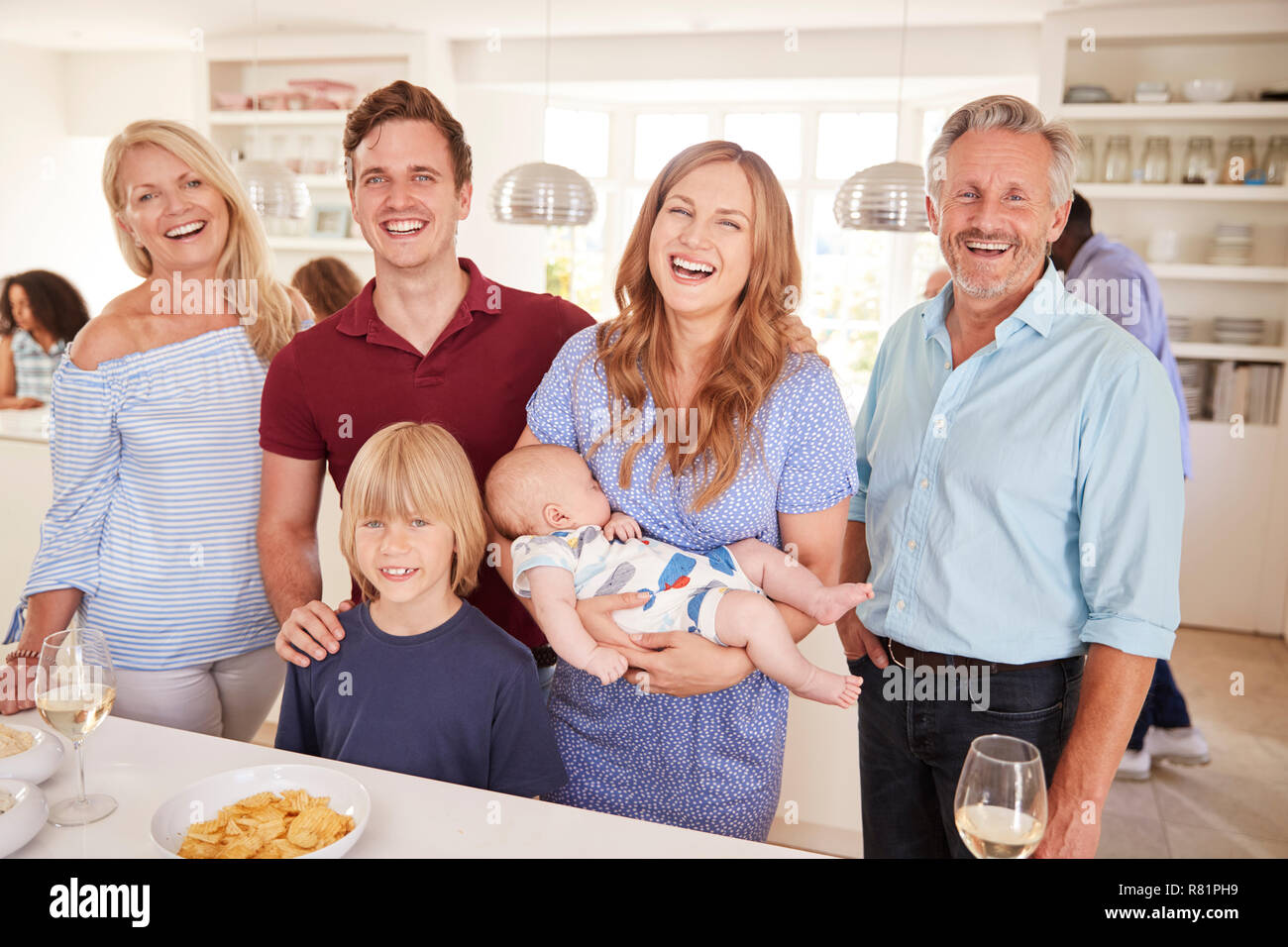 Ritratto di Multi-Generation la famiglia e gli amici raccogliendo in cucina per la Festa Foto Stock