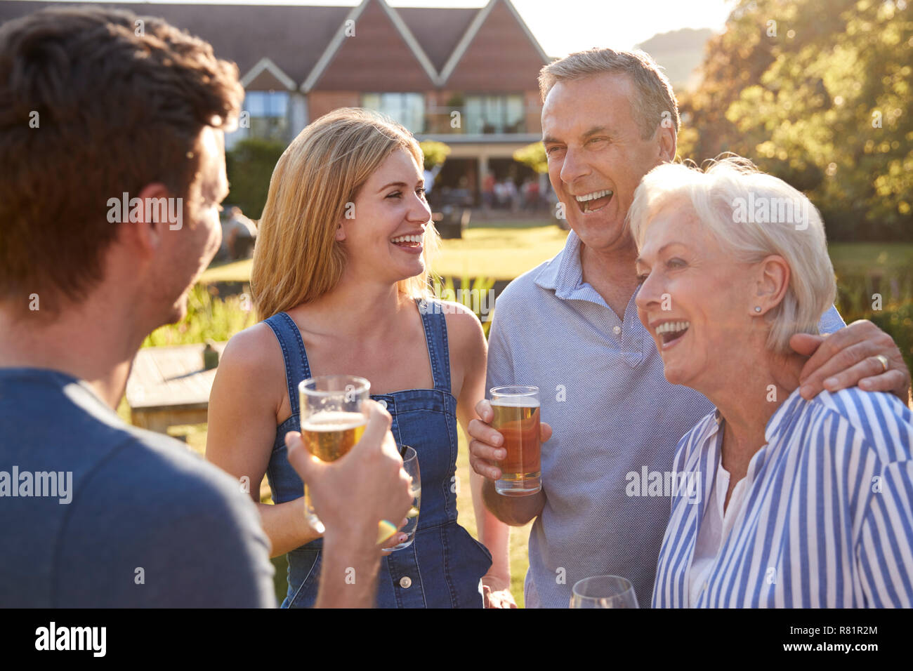 I genitori con adulto prole godendo dehor estivo drink al Pub Foto Stock