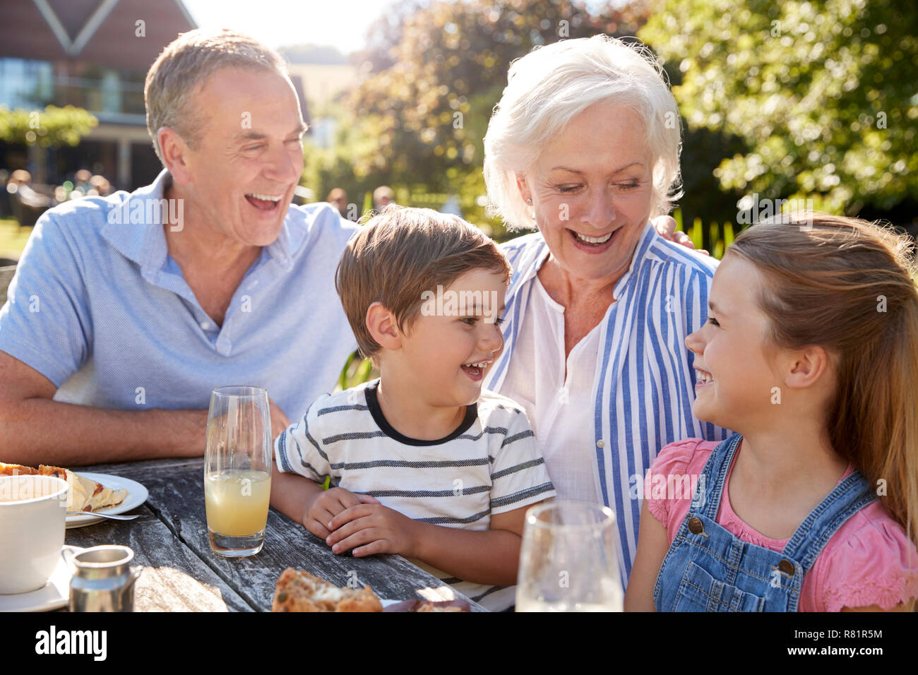 Nonni con i nipoti godendo dehor estivo Snack presso il Cafe Foto Stock