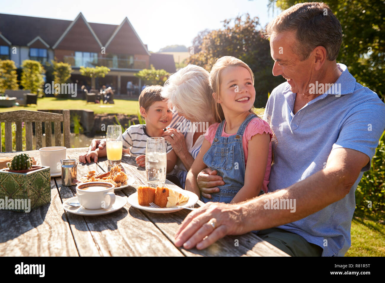 Nonni con i nipoti godendo dehor estivo Snack presso il Cafe Foto Stock