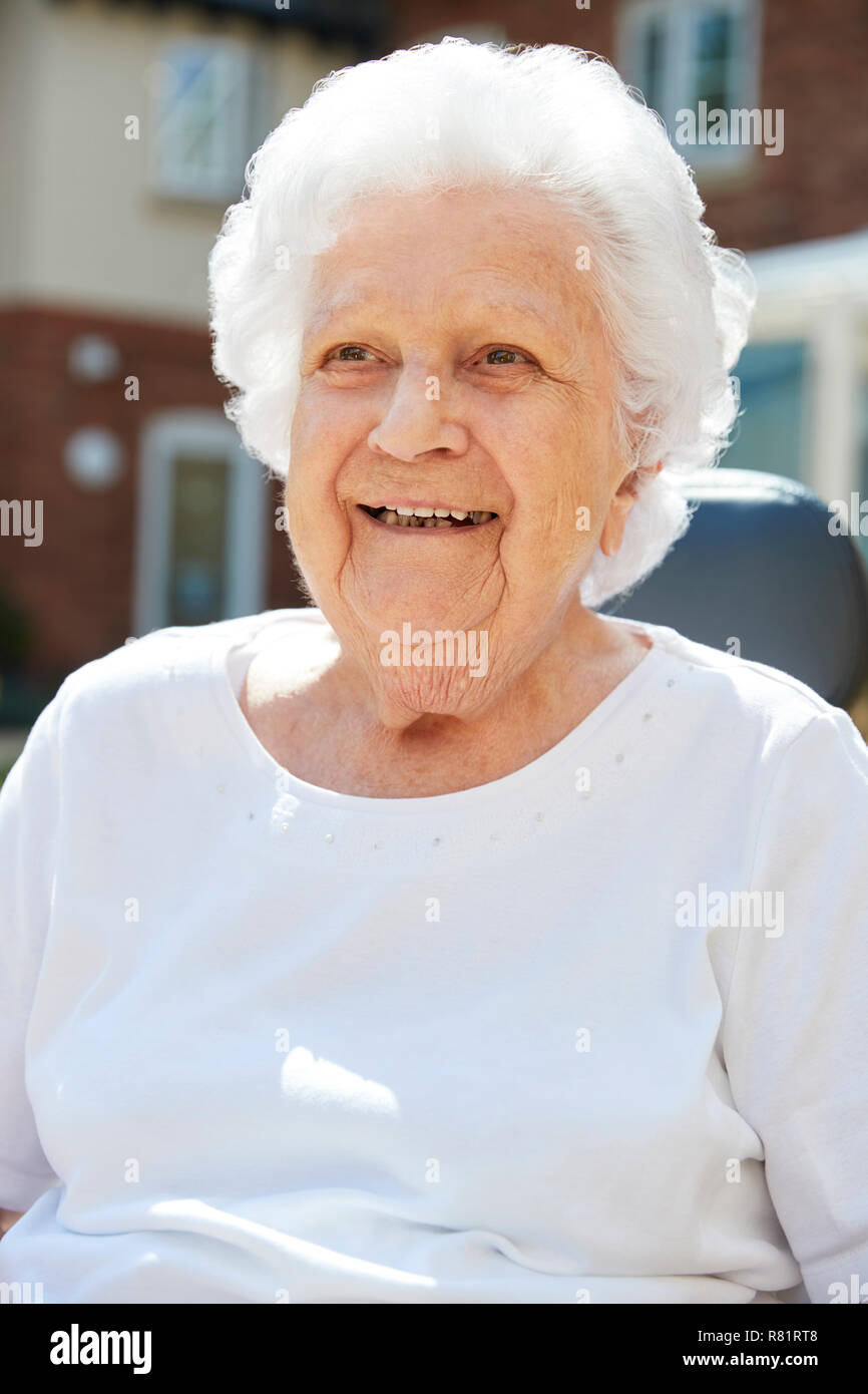 Ritratto di donna Senior seduto fuori casa di riposo Foto Stock