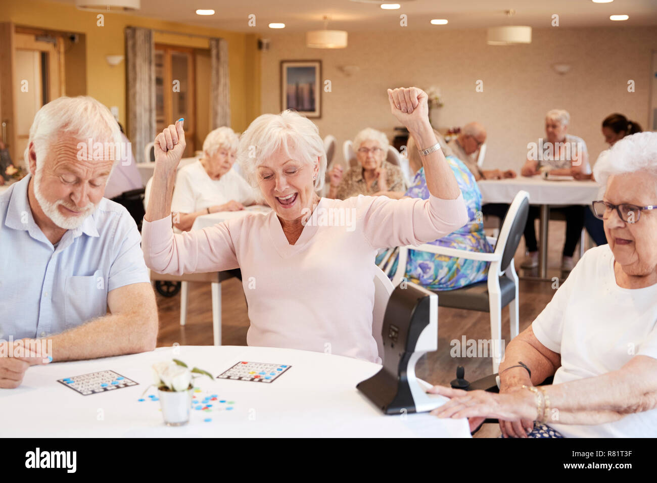 Senior donna gioco vincente del Bingo in casa di riposo Foto Stock