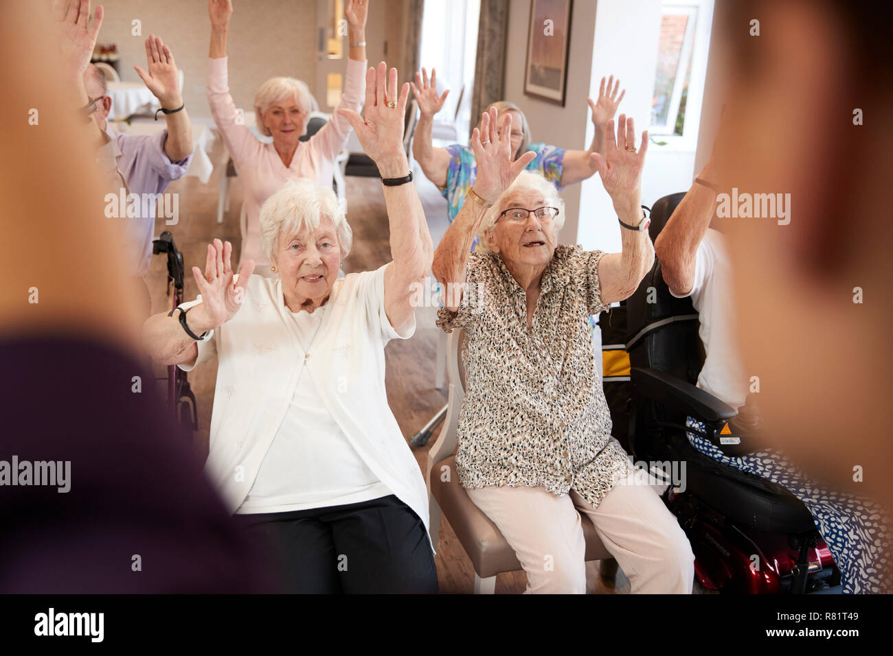 Accompagnatore Gruppo leader di anziani nella classe di Fitness in casa di riposo Foto Stock