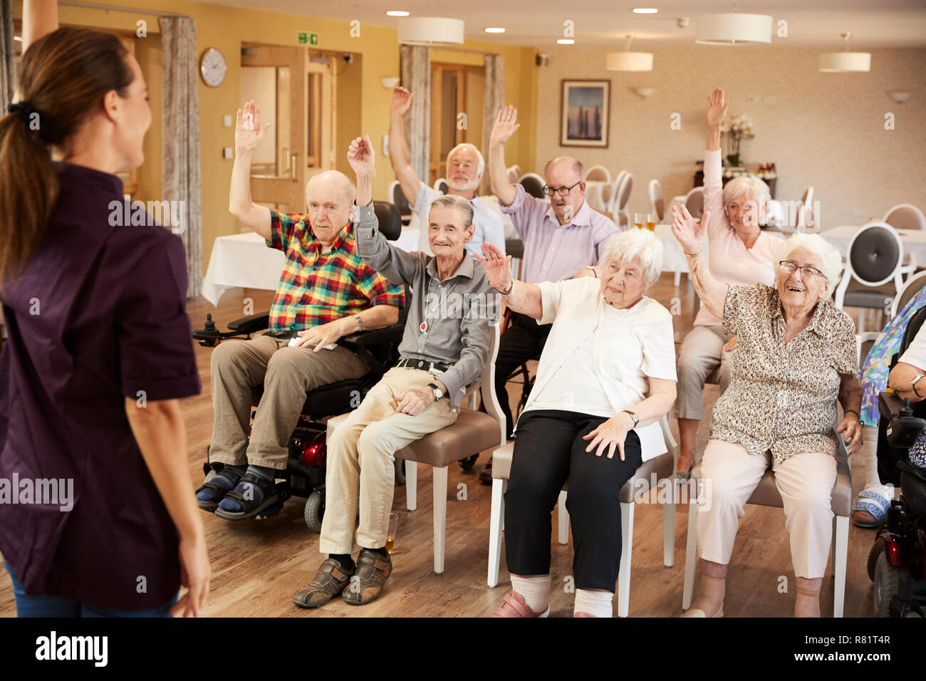 Accompagnatore Gruppo leader di anziani nella classe di Fitness in casa di riposo Foto Stock