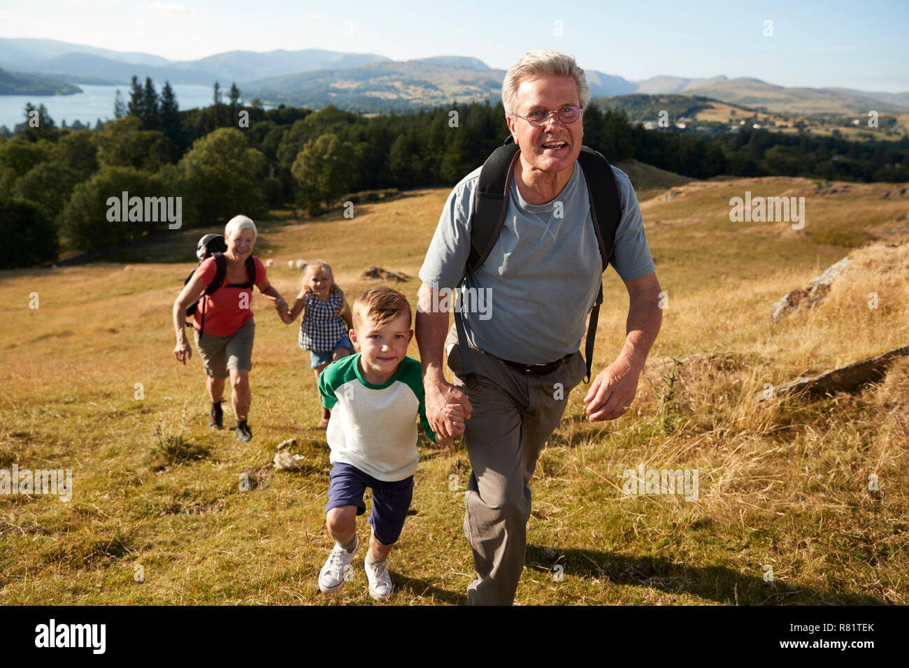 Nonni con i nipoti Salita sulla passeggiata attraverso la campagna nel Lake District UK insieme Foto Stock