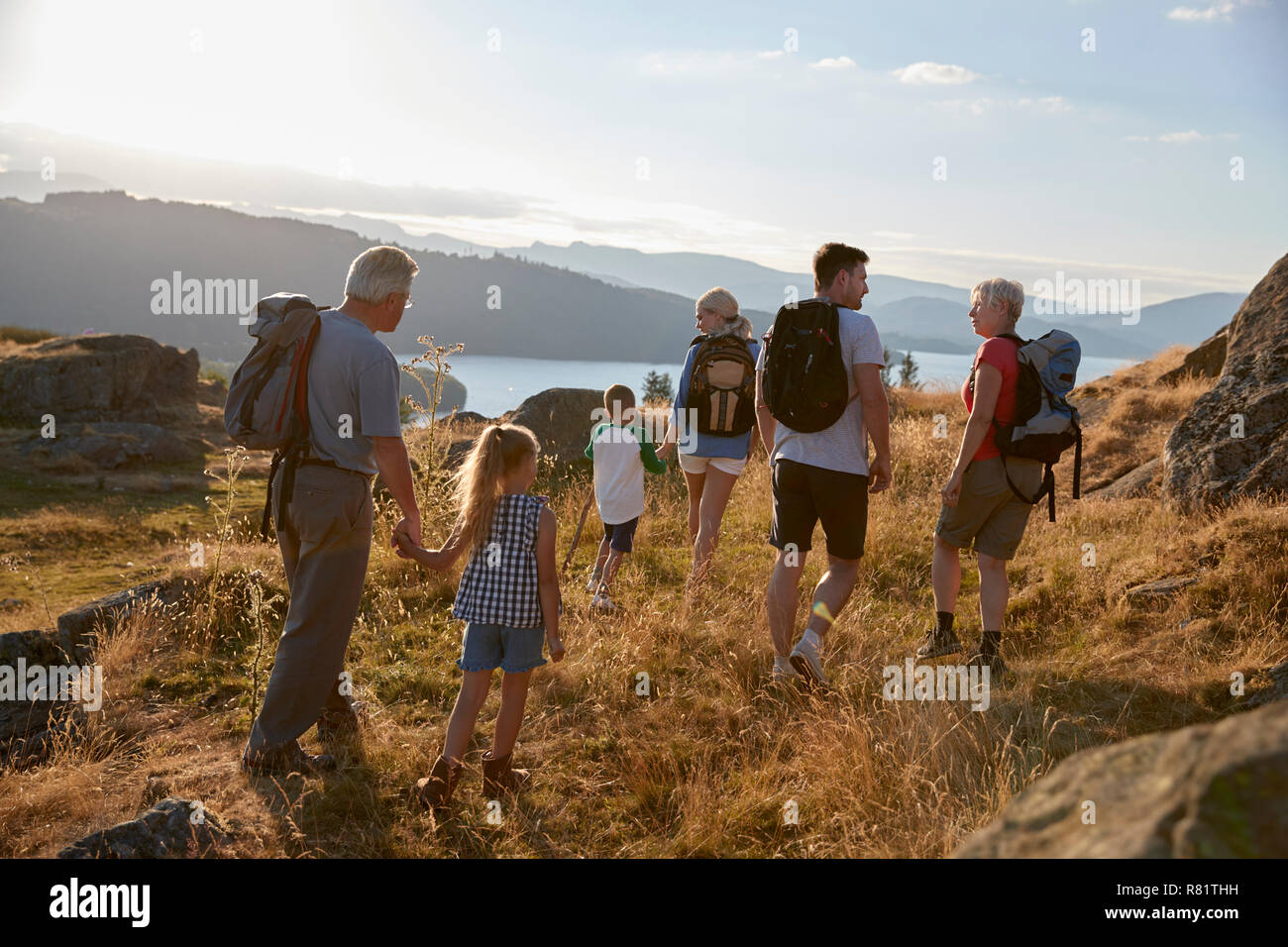 Vista posteriore del Multi generazione famiglia passeggiate sulla sommità di una collina sulla passeggiata attraverso la campagna nel Lake District UK Foto Stock