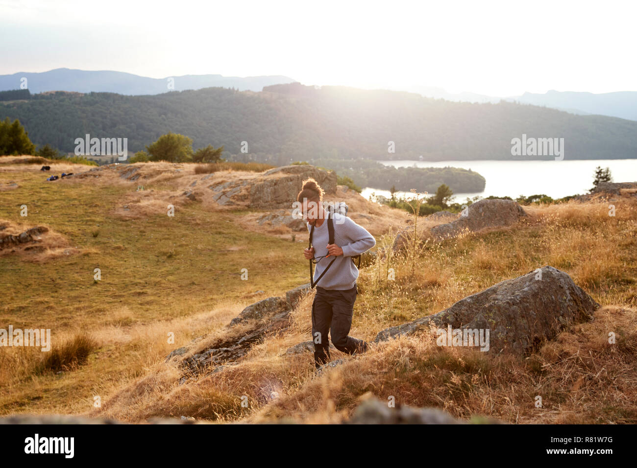 Un giovane razza mista uomo a camminare da soli in montagna Foto Stock