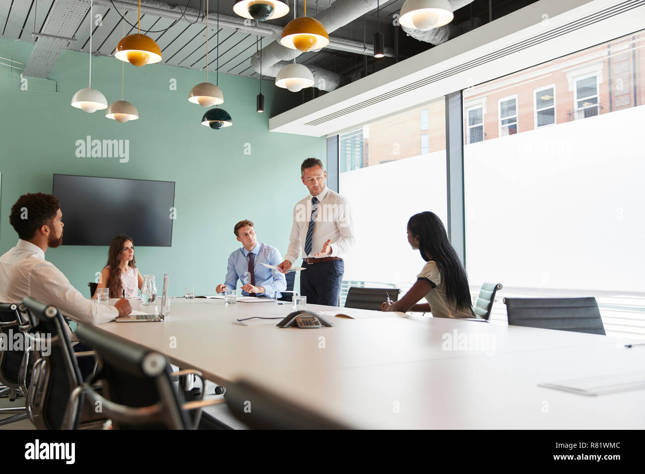 Imprenditore maturo dando presentazione nella sala consiliare di Colleghi in Sala Riunioni Foto Stock