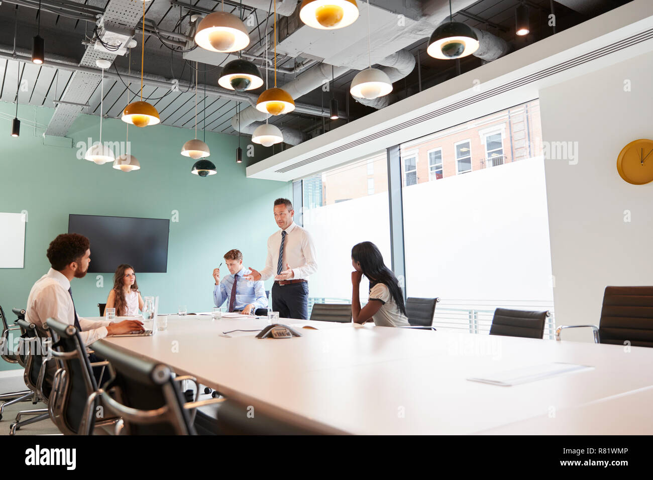 Imprenditore maturo dando presentazione nella sala consiliare di Colleghi in Sala Riunioni Foto Stock