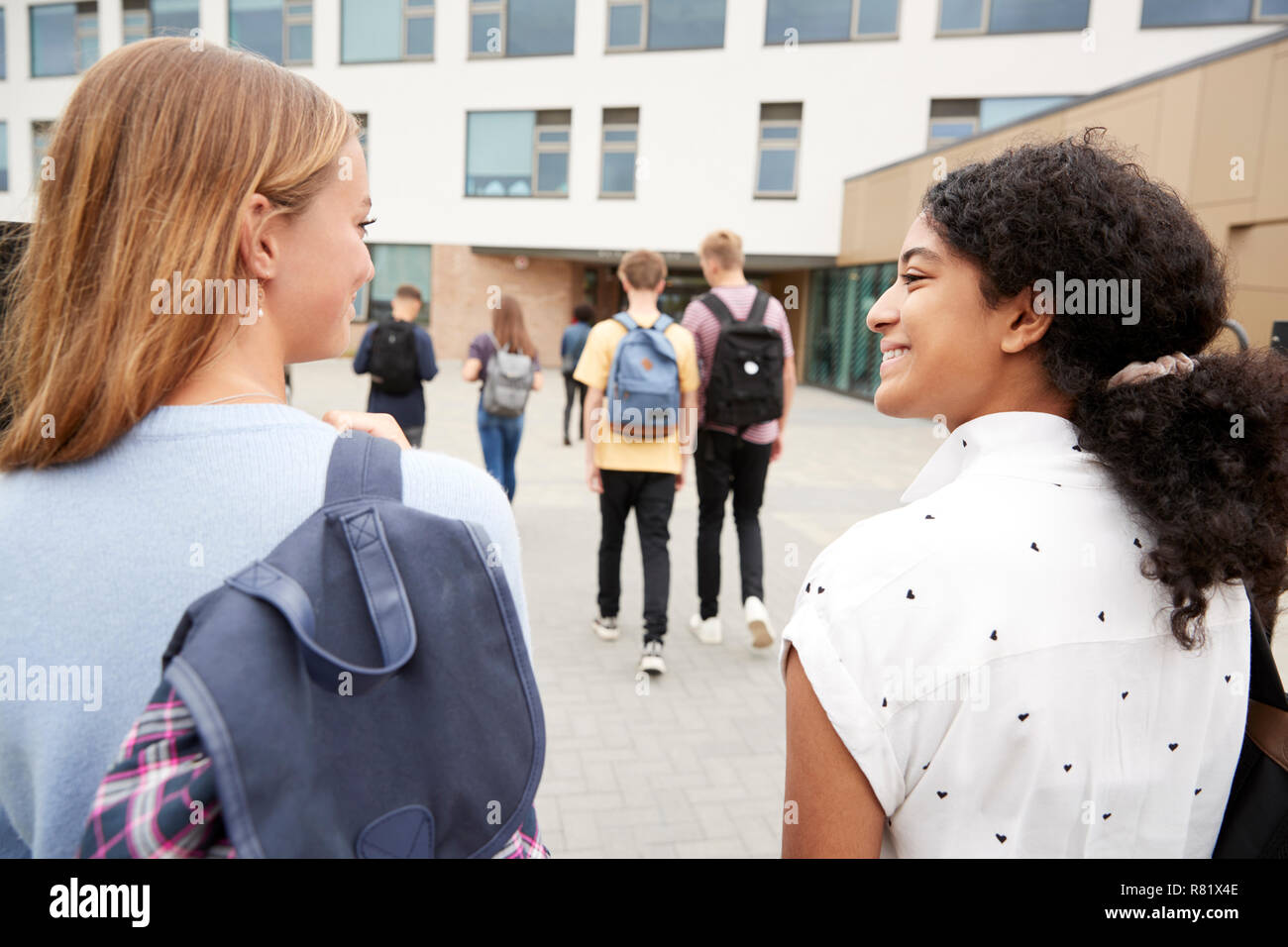 Vista posteriore di due femmina di alta scuola gli studenti a piedi in collegio a costruire insieme Foto Stock