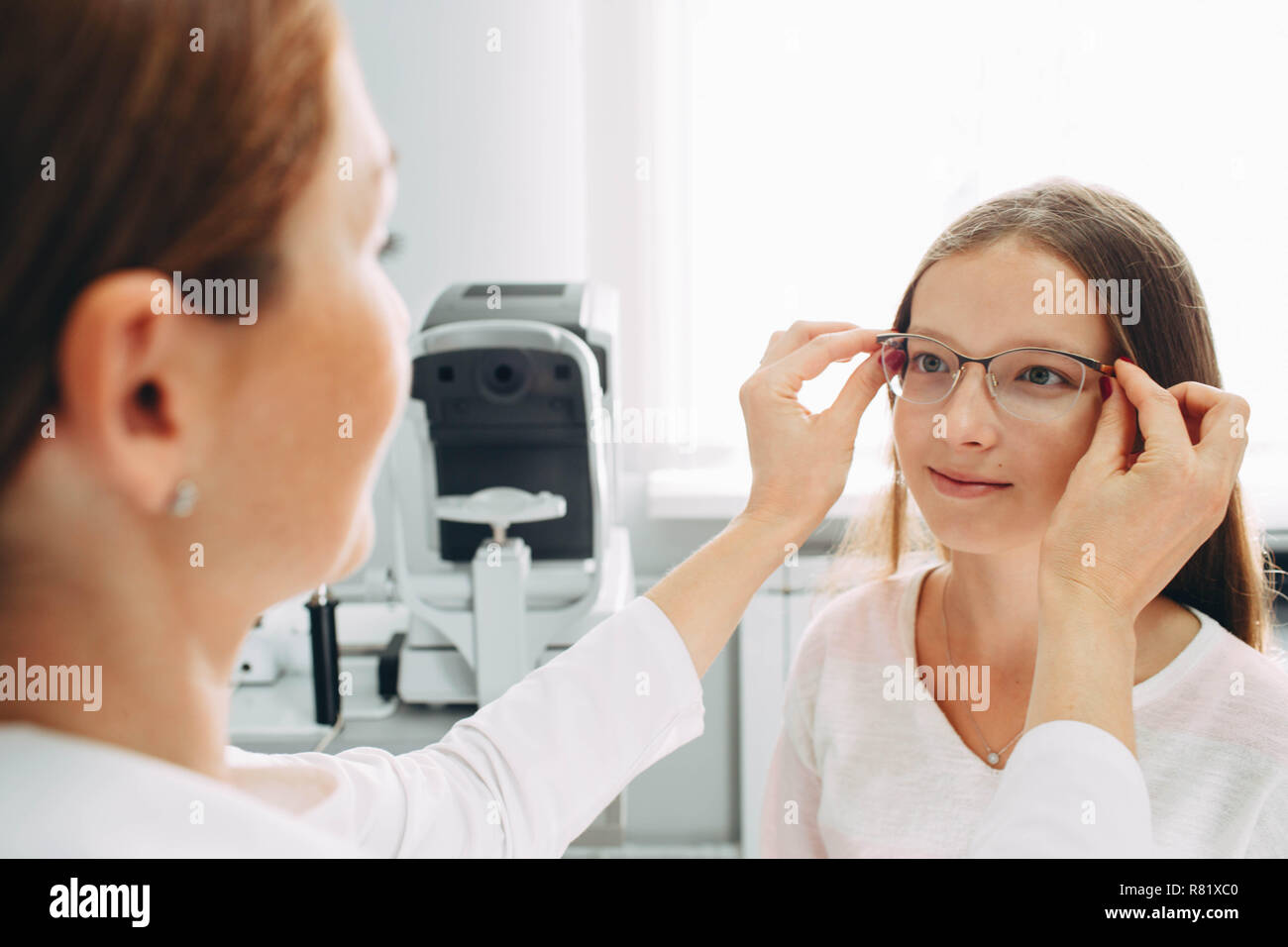 Teen girl provando nuovi occhiali a ottico office Foto Stock