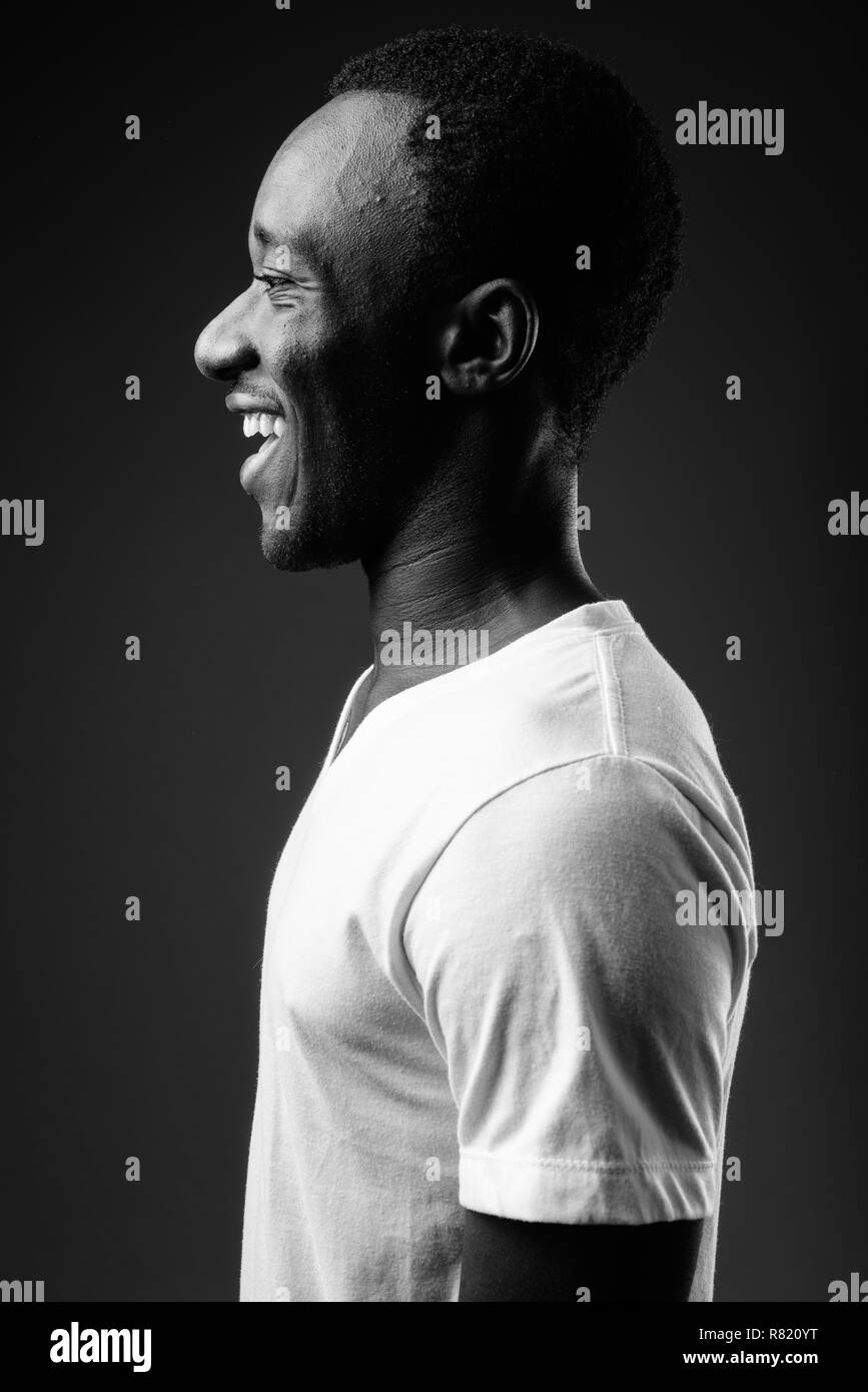 Vista di profilo Ritratto di giovane africano sorridente in bianco e nero Foto Stock