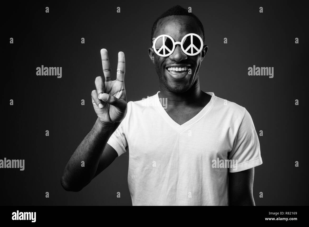 Giovane africano indossando occhiali da sole di pace e rendere gesto pacifica Foto Stock