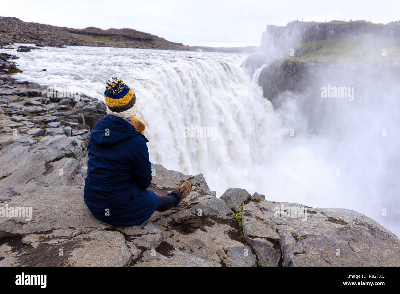 Donna alla cascata di Dettifoss godendo la vista / Frau am Wasserfall Dettifoss Genießen fascio des Ausblicks Foto Stock