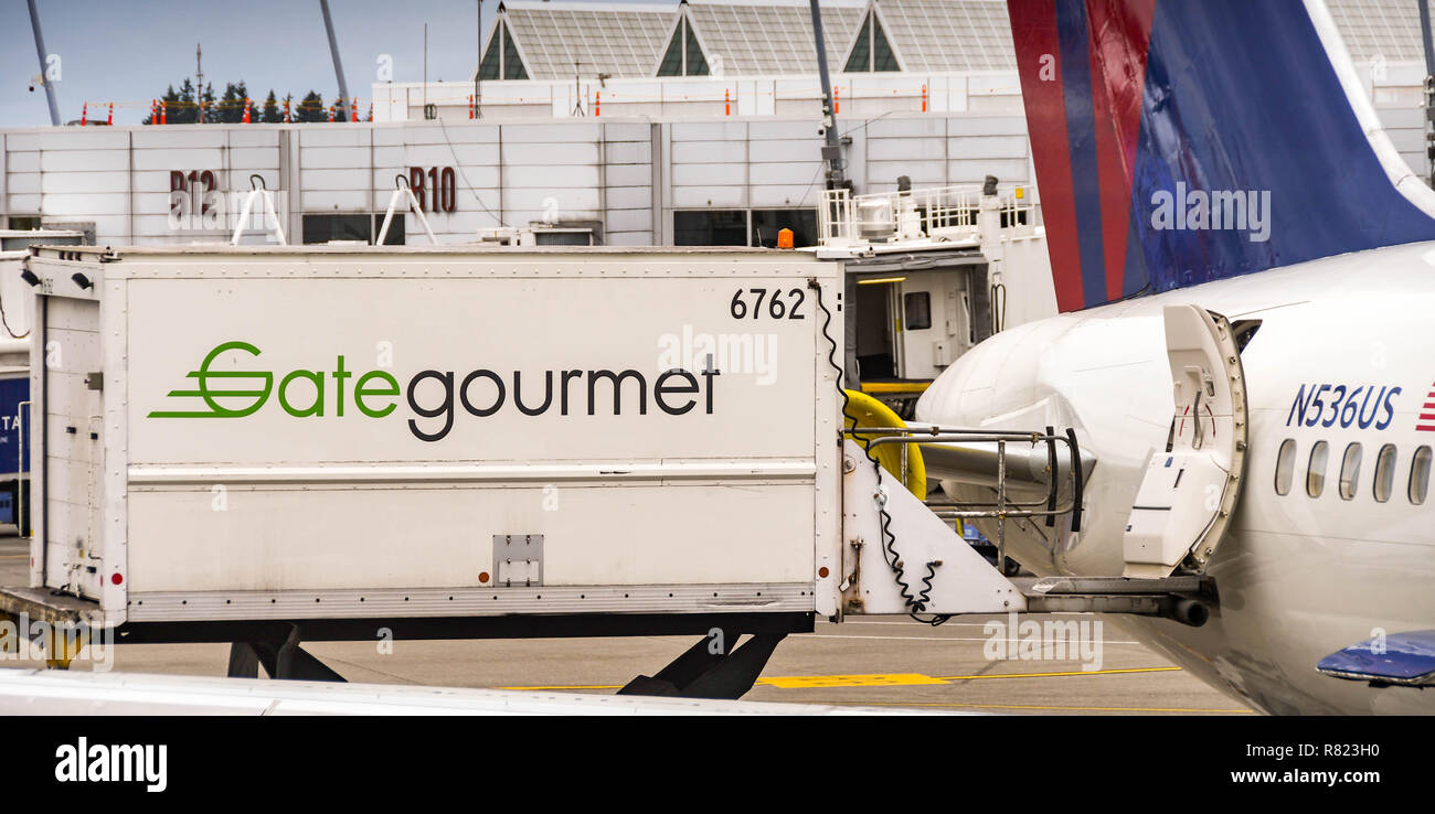 SEATTLE TACOMA AIRPORT, WA, Stati Uniti d'America - Giugno 2018: Gate Gourmet di sollevamento idraulico il caricamento dei camion di cibo e altre forniture di catering su un Delta Airlines Boeing 7 Foto Stock