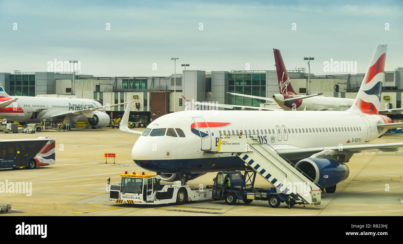 Dall'Aeroporto Heathrow di Londra, Inghilterra - Giugno 2018: British Airways Airbus A320 all'Aeroporto di Londra Heathrow, con rimorchiatore e scale passeggeri Foto Stock