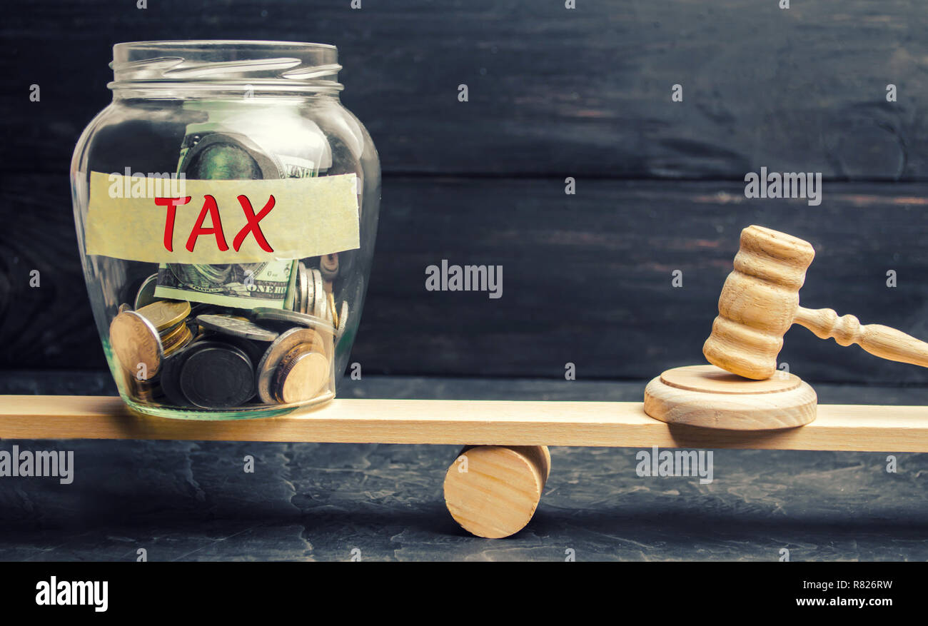 Vaso di vetro con monete e l'iscrizione ' ' fiscali sulle scale. Il concetto di legge. Corte di giustizia e di giudizio. La giustizia e la legalità. I legislatori, administrat pubblica Foto Stock