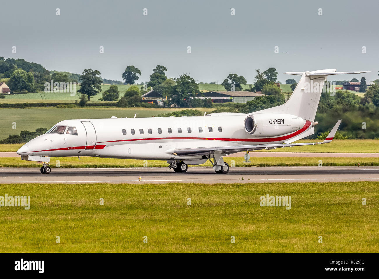 Un Embraer Legacy Business Jet Executive il piano, registrazione G-PEPI, decollo dall'Aeroporto London Luton in Inghilterra. Foto Stock