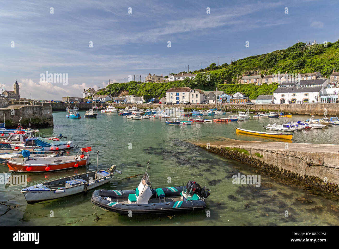 La città costiera di Porthleven in Cornovaglia, Inghilterra, mostrando piccole barche nel porto e gli edifici circostanti. Foto Stock