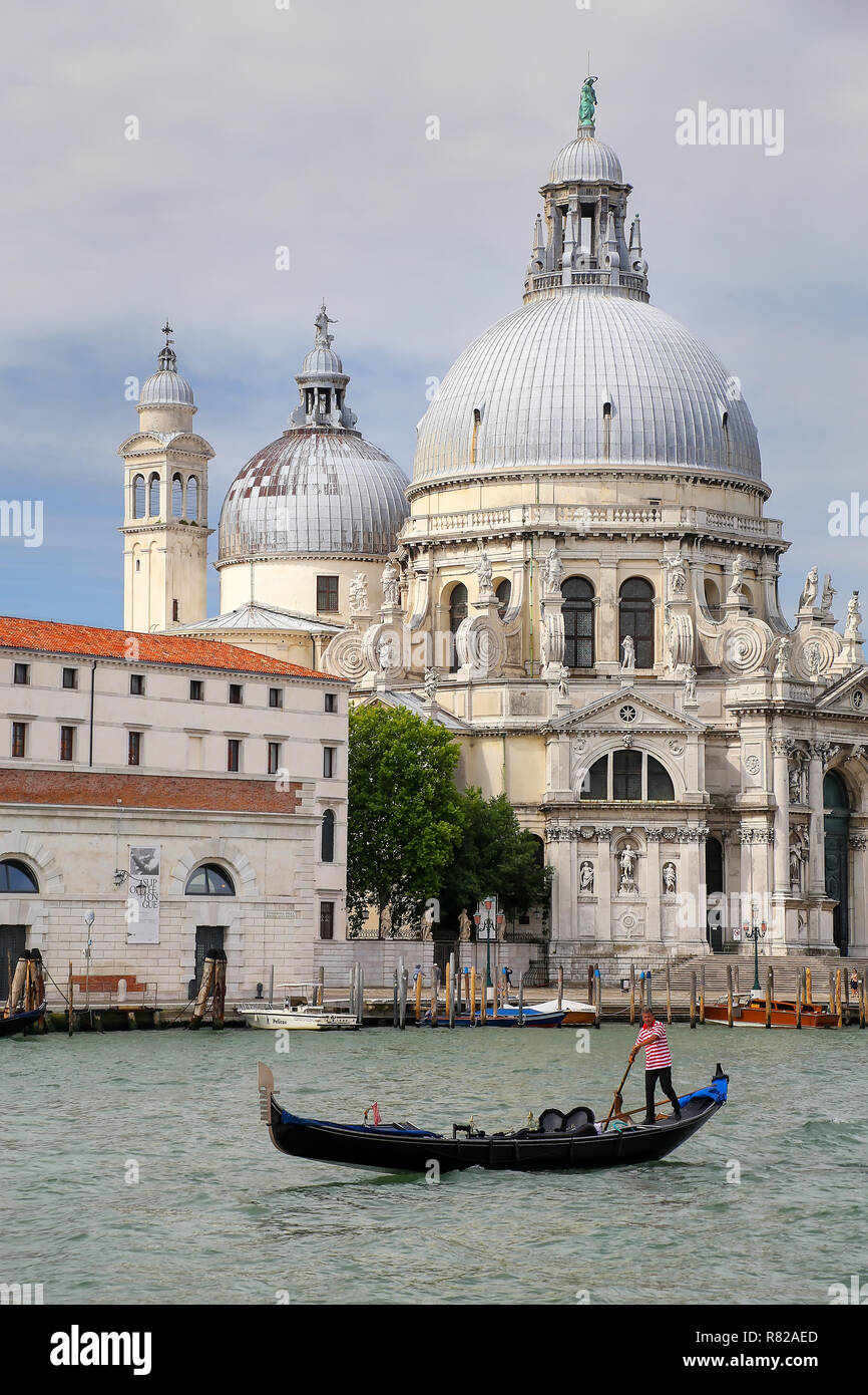 Gondola si muove di fronte alla Basilica di Santa Maria della Salute a Venezia, Italia. Questa chiesa è stata voluta da Venezia la peste superstiti come grazie f Foto Stock