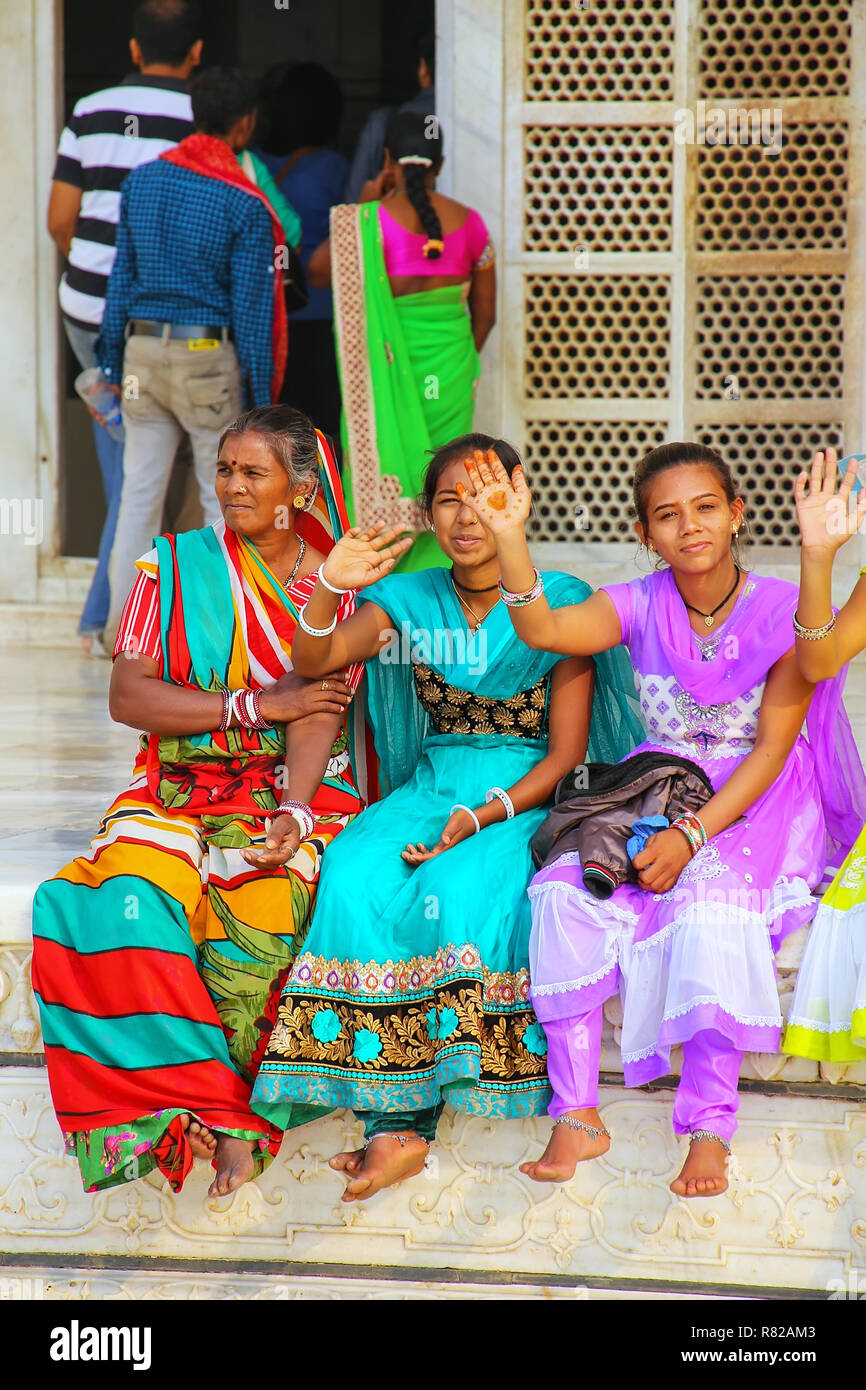 Le donne in sari colorati seduta al di fuori del Taj Mahal di Agra, Uttar Pradesh, India. Taj Mahal è stato designato come un Sito Patrimonio Mondiale dell'UNESCO nel 1983. Foto Stock