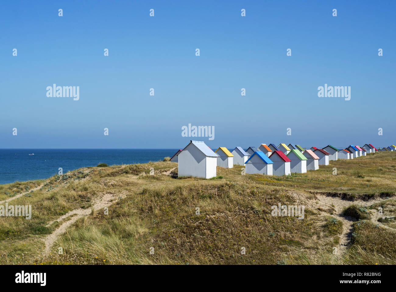 Riga di colorate cabine da spiaggia nelle dune a Gouville-sur-Mer, Bassa Normandia, Francia Foto Stock