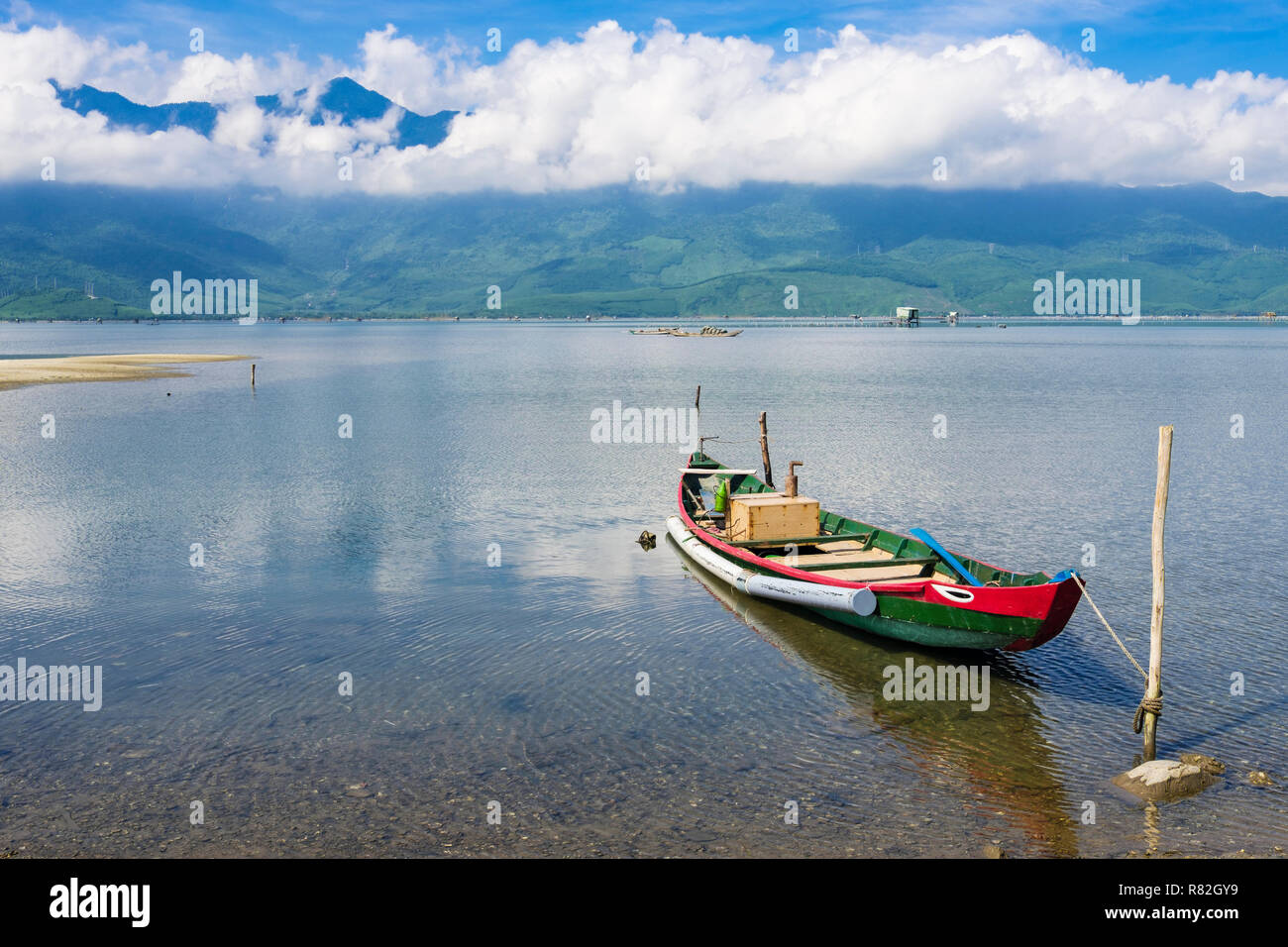 Alle tradizionali piccole barche da pesca sul giro di una laguna con montagne in Bạch Mã National Park oltre. Lang Co, l'unità PHU Loc, Thua Thien Huê, Vietnam Asia Foto Stock