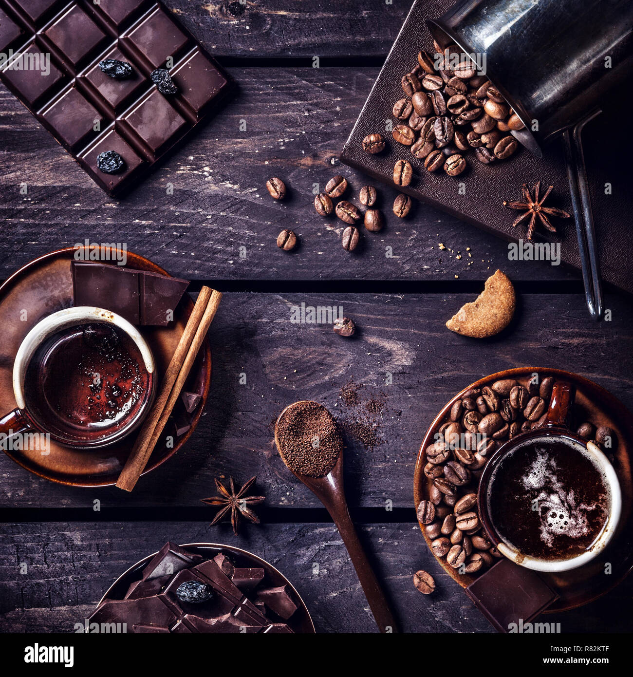 Il caffè e il cioccolato fondente con spezie nel buio di un tavolo di legno Foto Stock