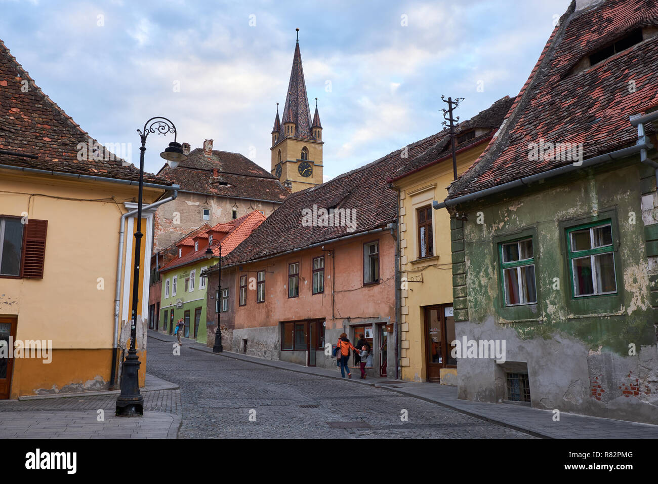 Tipiche pietre ciottoli street della città di Sibiu Romania, con case colorate, campanile e la luce post Foto Stock