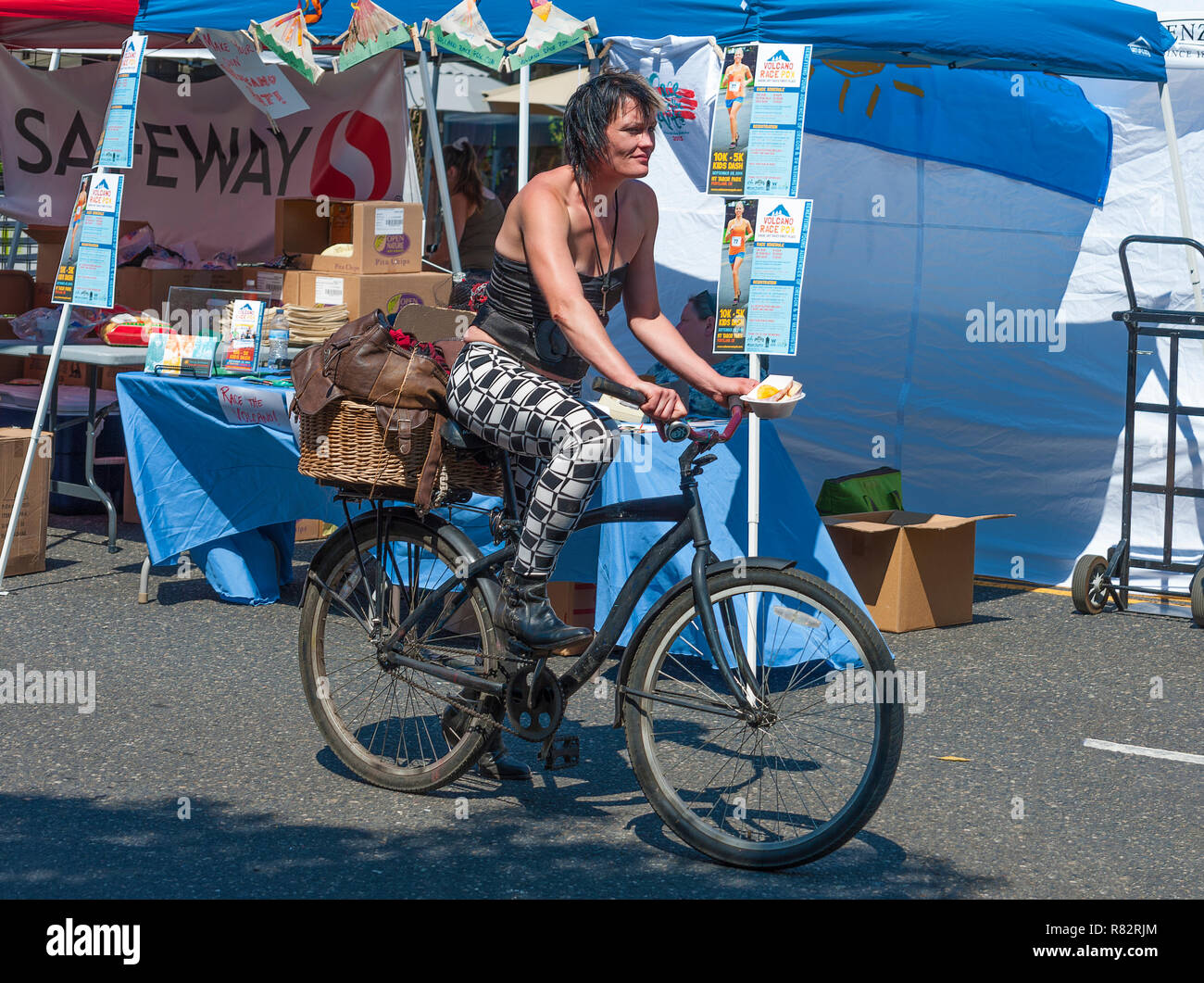 Portland, Oregon, Stati Uniti d'America - agosto 17,2014: Biancospino Street annuale evento comunitario. Una signora cavalca il suo moto il contenimento di cibo che aveva appena acquistato da una cabina Foto Stock