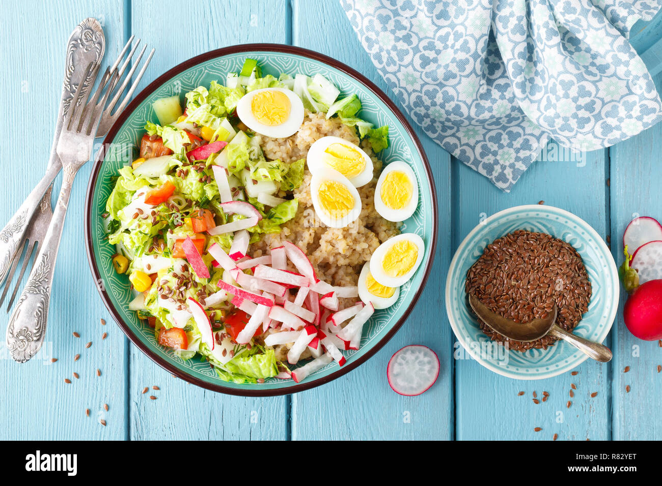 Ciotola con farinata di grano, bollito uova di quaglia e verdura fresca insalata di radicchio, mais, peperoni e cavolo cinese. Sana e deliziosa integratore Foto Stock