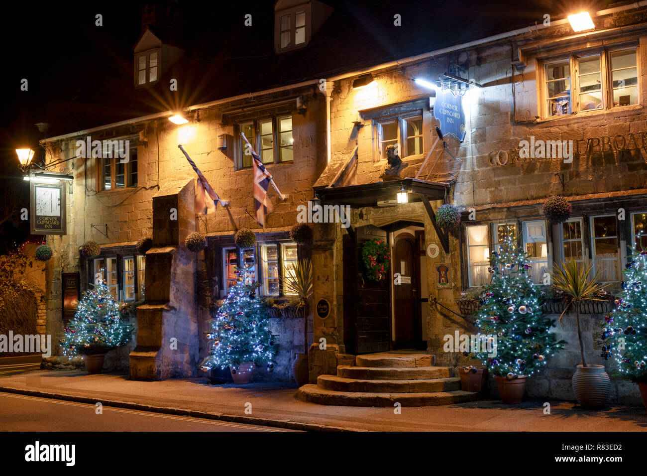 Angoliera inn e alberi di Natale di notte. Winchcombe, Cotswolds, Gloucestershire, Inghilterra Foto Stock