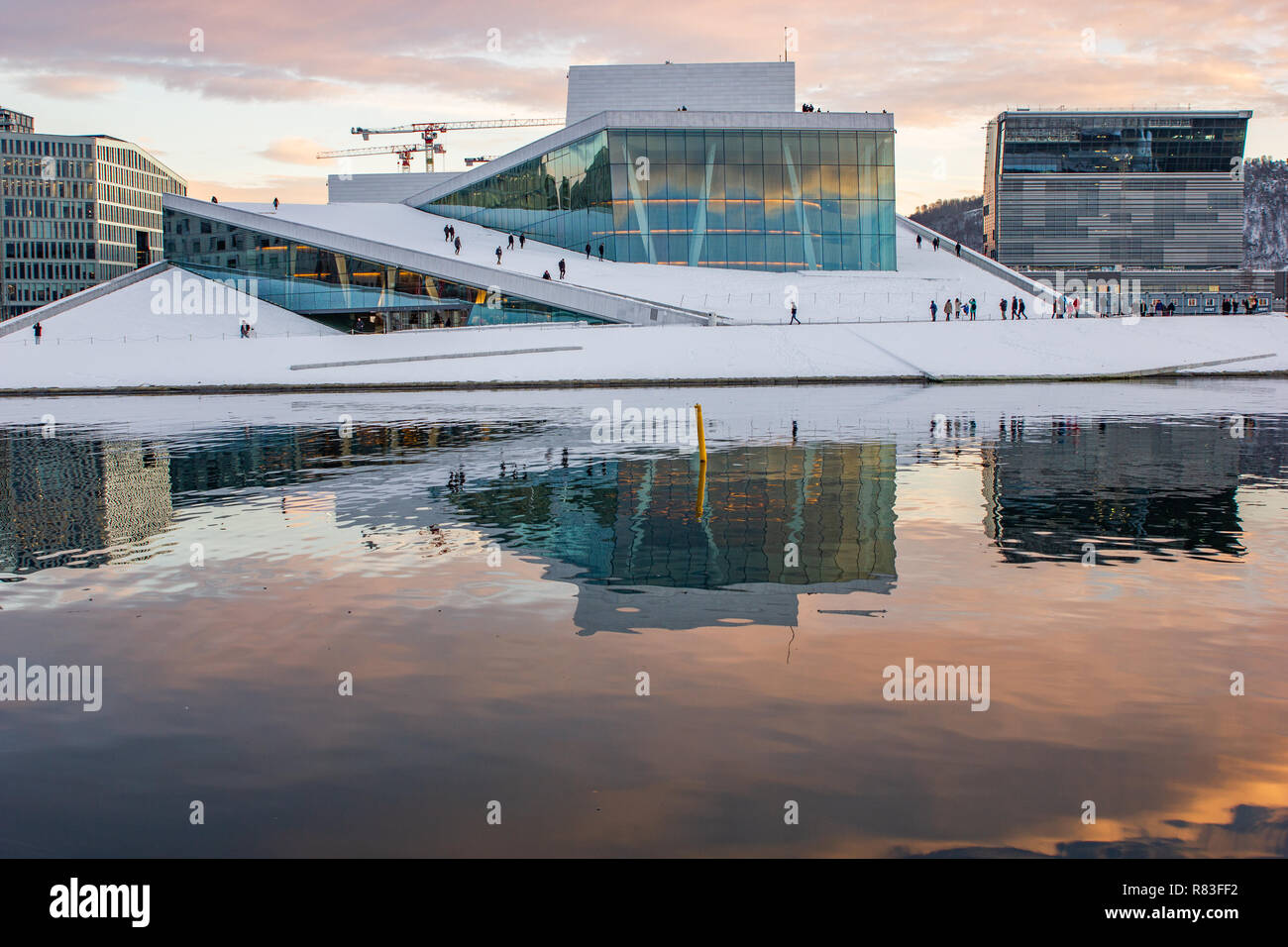 Norwegian Opera house e il nuovo museo di Munch in costruzione al tramonto in inverno a Oslo, Norvegia Foto Stock