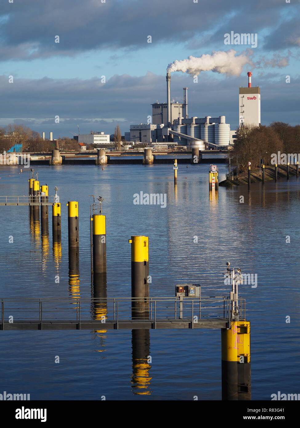 Bremen, Germania - Dicembre 11th, 2018 - Centrale idroelettrica sul fiume Weser con fila di giallo posti di ormeggio in primo piano Foto Stock