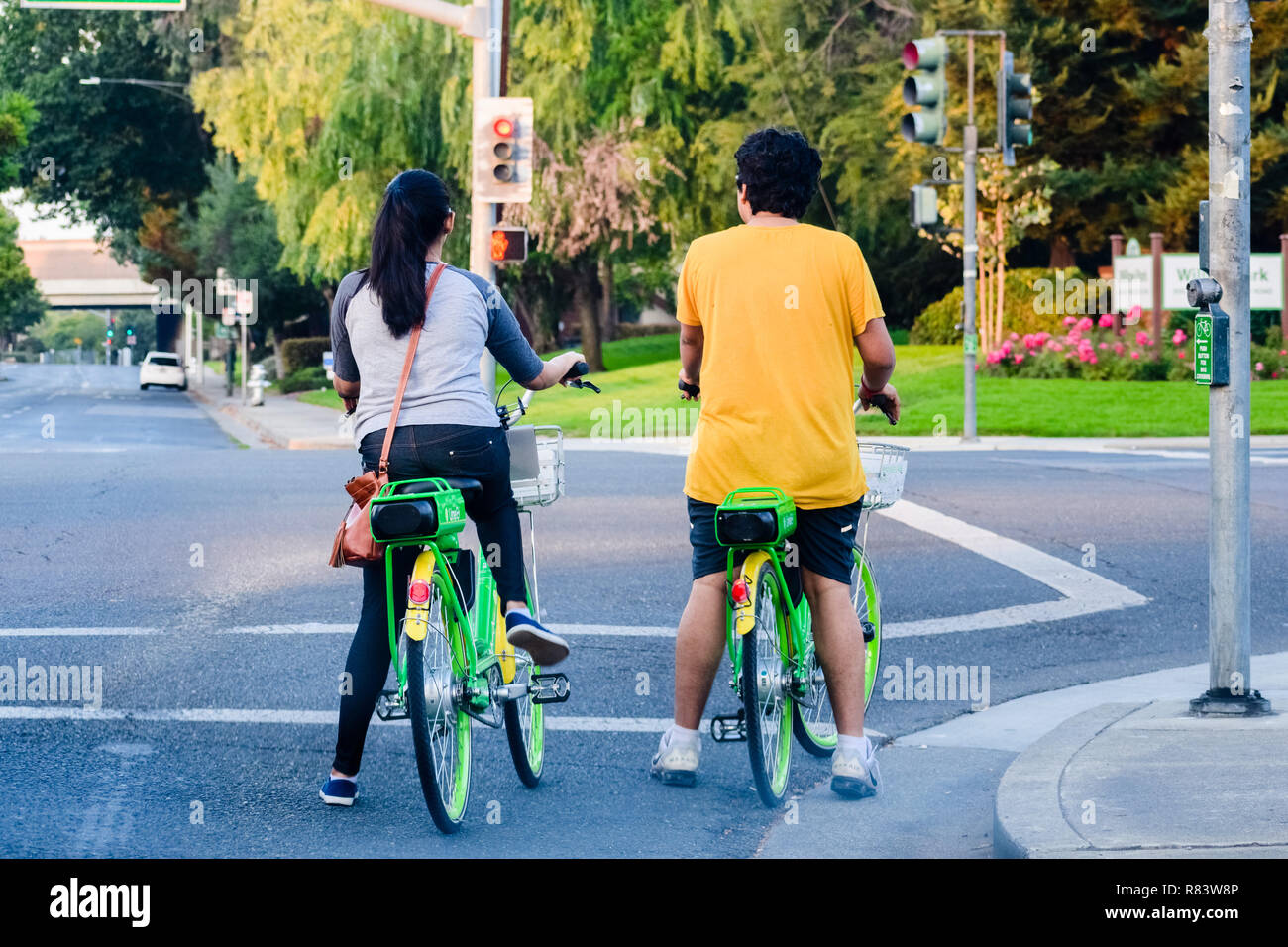 3 settembre 2018 Mountain View / CA / STATI UNITI D'AMERICA - Coppia di equitazione biciclette a calce, in attesa al semaforo verde per attivare; calce è un American transportation Foto Stock